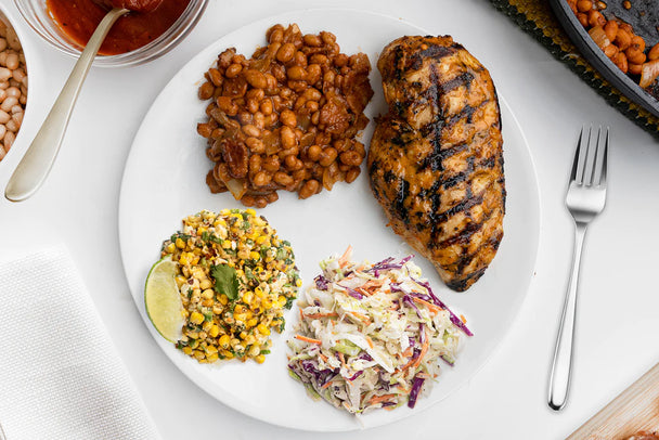 A large bowl of Mexican Street corn next to a jar of Primal Kitchen Mayo