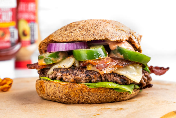 A jalapeno burger on a grain-free bun with Primal Kitchen condiments in the background.