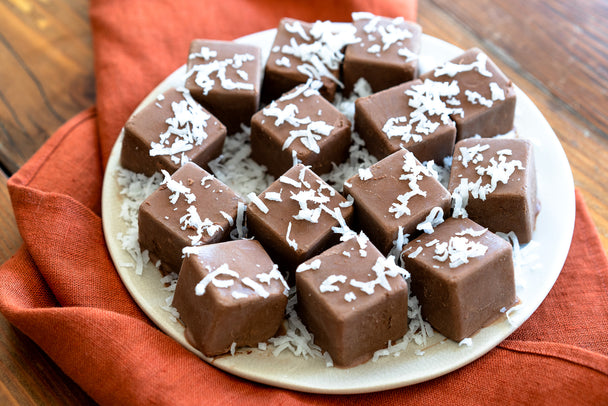 Chocolate Coconut Fat Bombs on a white plate, with an orange napkin underneath.