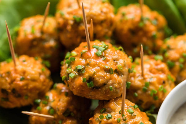  Closeup on a pile of chicken meatballs made with Primal Kitchen Buffalo Sauce. 