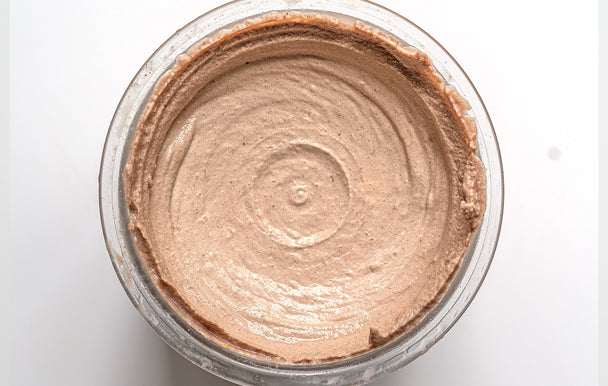 Overhead view of swirled chocolate collagen ice cream in a Ninja CREAMi container. 