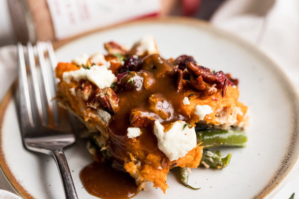 A serving of leftover turkey casserole on a white plate, with a fork.