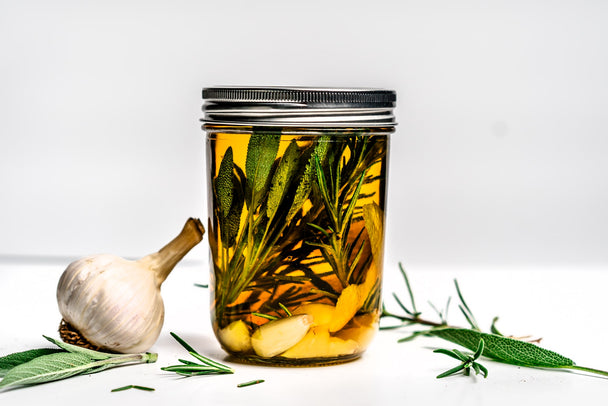 A mason jar of garlic-infused avocado oil made with Primal Kitchen Avocado Oil. 