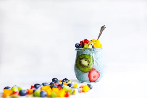 A clear jar of collagen chia seed pudding with fruit.