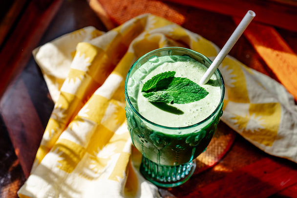 Overhead view of a shamrock shake in a green glass, with a yellow patterned napkin on the side.