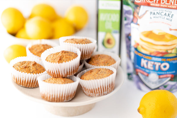 A plate of lemon poppyseed muffins nect to a package of pancake mix.