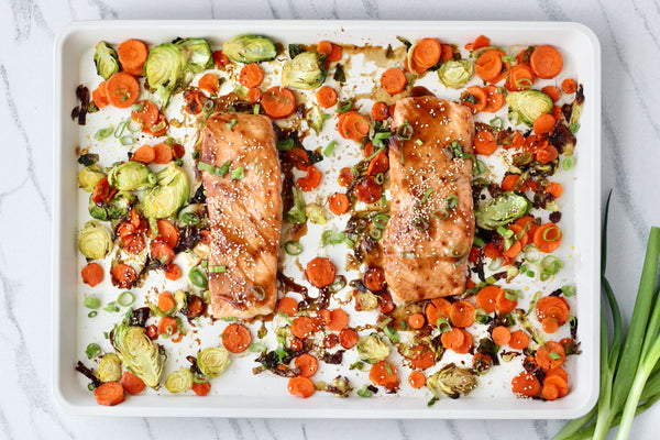 A tray of sheet pan salmon with roasted veggies. 