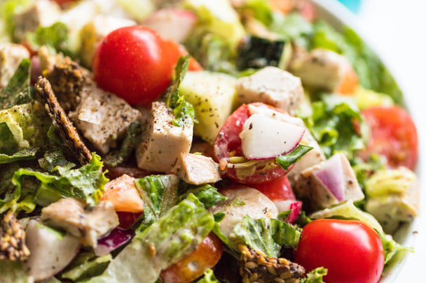 Closeup on a ranch chopped salad in a white bowl.