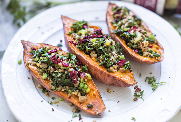 Three stuffed sweet potato halves on a white plate. 