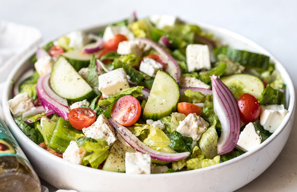 A Greek salad in a white bowl.