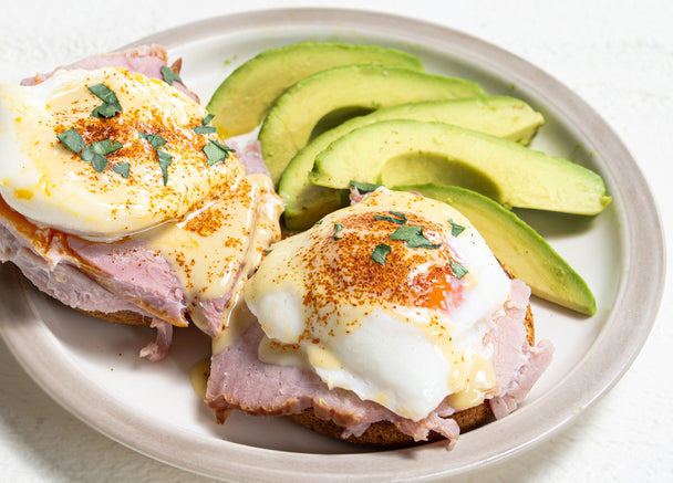 A plate of eggs Benedict with mock hollandaise sauce and a dash of paprika.