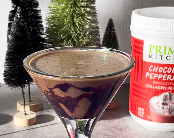 Peppermint mocha with a chocolate swirl in a martini glass, with a Primal Kitchen Chocolate Peppermint Collagen canister in the background. 