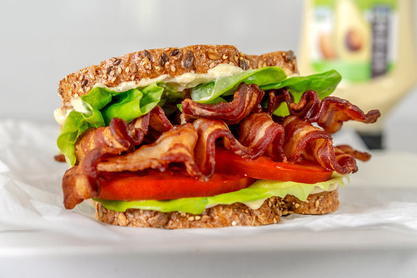 A tasty BLT sandwich made with Avocado Mayo on a white napkin..