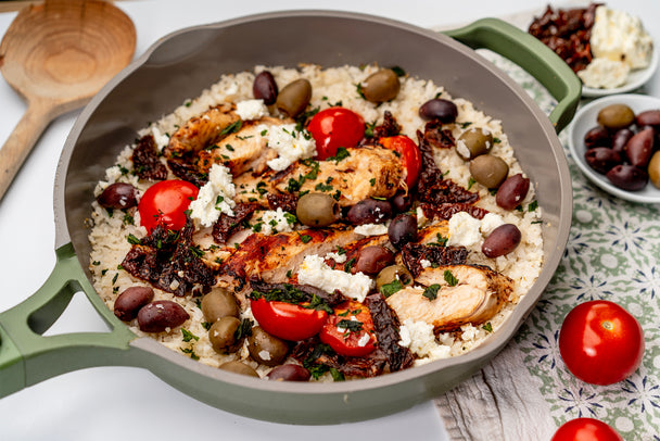 A Mediterranean Chicken Skillet with cauliflower rice, olives, tomatoes, and feta. 