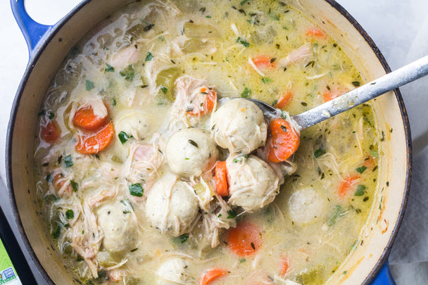 Overhead view of chicken and dumpling soup in a blue pot.