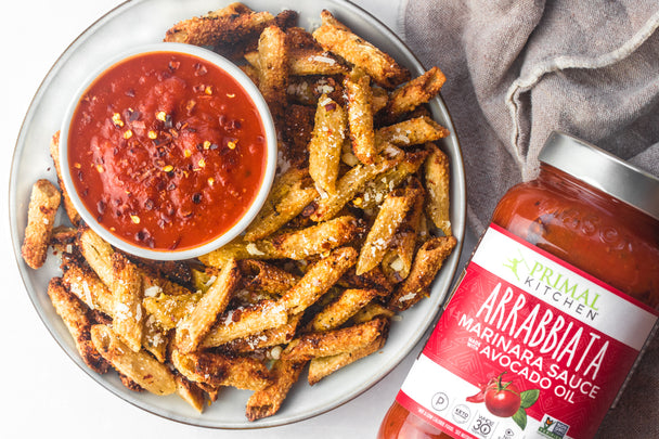 A plate of airfryer pasta chips surround a ramakin with primal kitchen arrabbiata sauce.