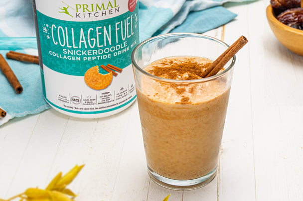 Snickerdoodle smoothie in a glass with a cinnamon stick next to Primal Kitchen Collagen Fuel Snickerdoodle