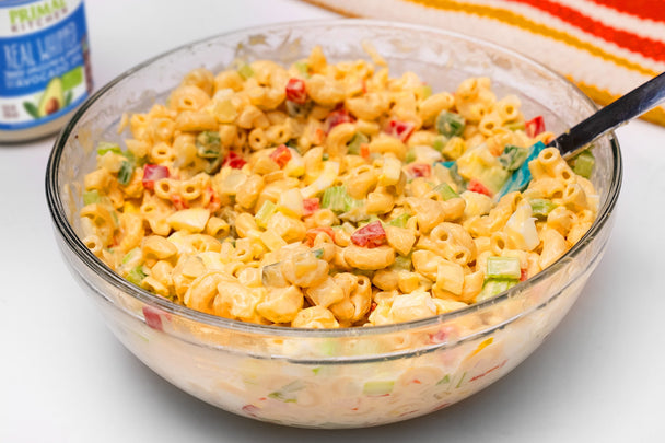 Overhead shot of a bowl of macaroni salad made with chickpea elbows, eggs, veggies, and Primal Kitchen Real Whipped.