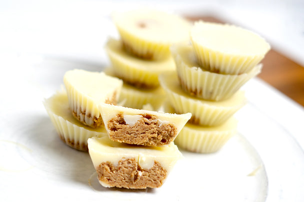 White chocolate peanut butter cups stacked up on a white plate