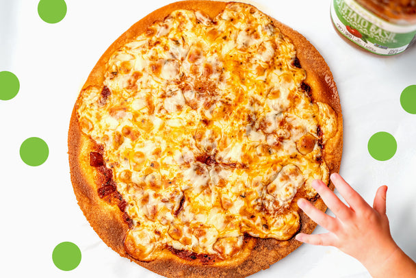 Child's hand reaching for baked cheese pizza