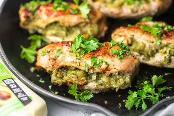 Closeup of a broccoli and cheese stuffed chicken breast in a pan. 