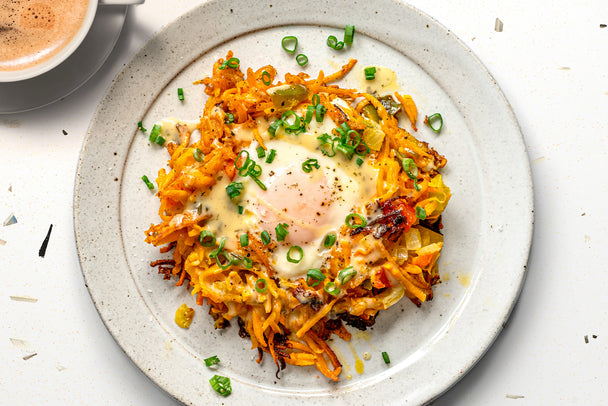 A sweet potato nest with an egg in the center, on a white plate. 