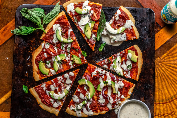 Avocado Ranch Pizza cut into pieces on a pizza sheet