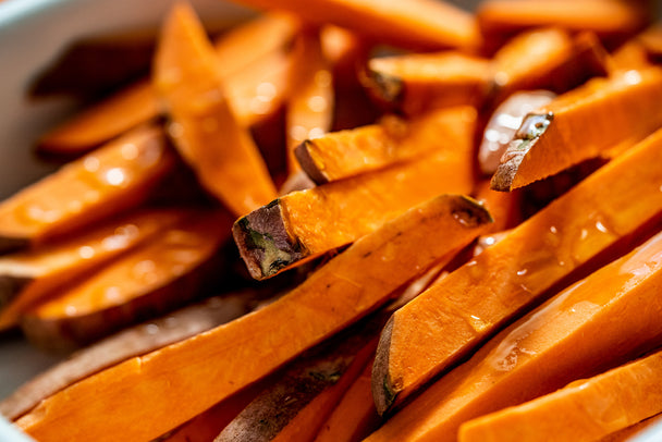 A plate of Airfryer Sweet Potato fries is arranged on a white plate with Ranch Dressing