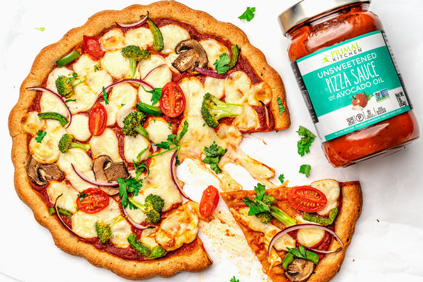 veggie pizza with red sauce next to Primal Kitchen Pizza Sauce