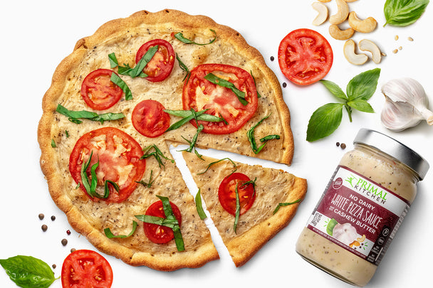 White pizza sauce is shown next to a grain free crust topped with basil, tomatoes, and sauce.