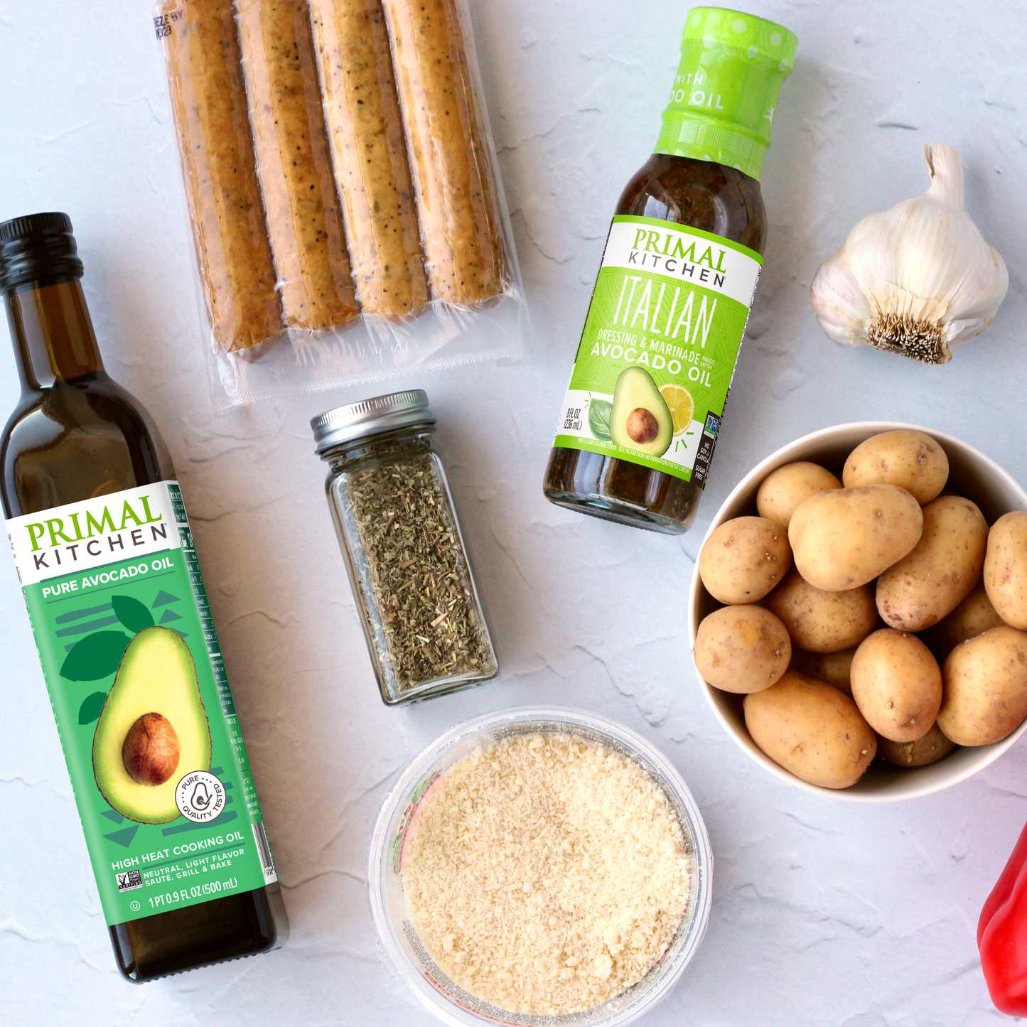 Primal Kitchen Avocado Oil and Italian Dressing and Marinade surrounded by ingredients.