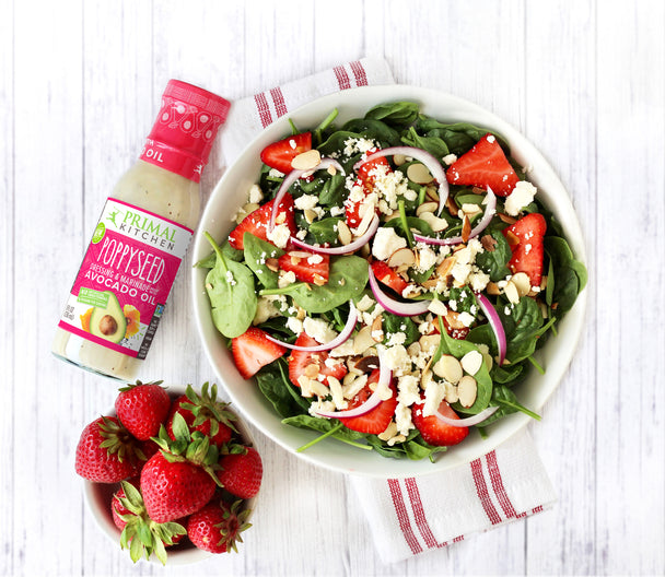 Primal Kitchen Poppyseed with a bowl of Strawberry spinach salad.