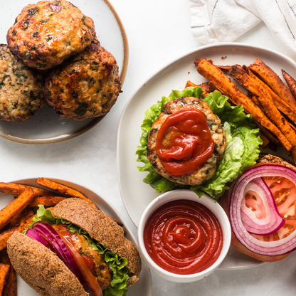 Air Fryer turkey burgers topped with ketchup and a side of Primal Kitchen ketchup for dipping.