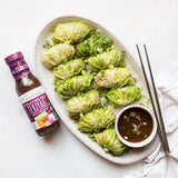 Primal Kitchen Thick & Sticky Honey Teriyaki with a plate of cabbage dumplings.