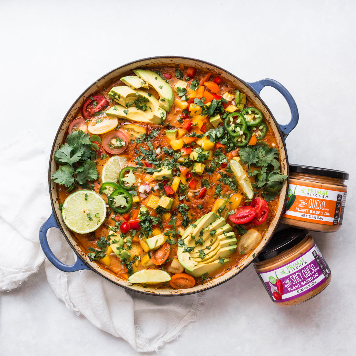 Primal Kitchen Queso Dips next to a pot of Chicken con Queso.